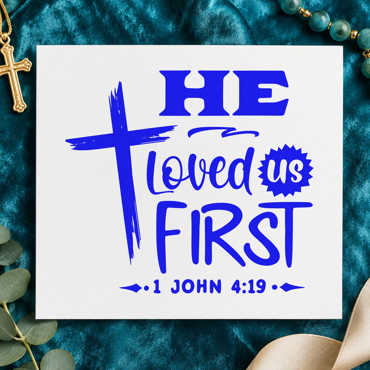 He Loved Us First craft stamp in blue ink on cardstock, an easy option for canvas totes.