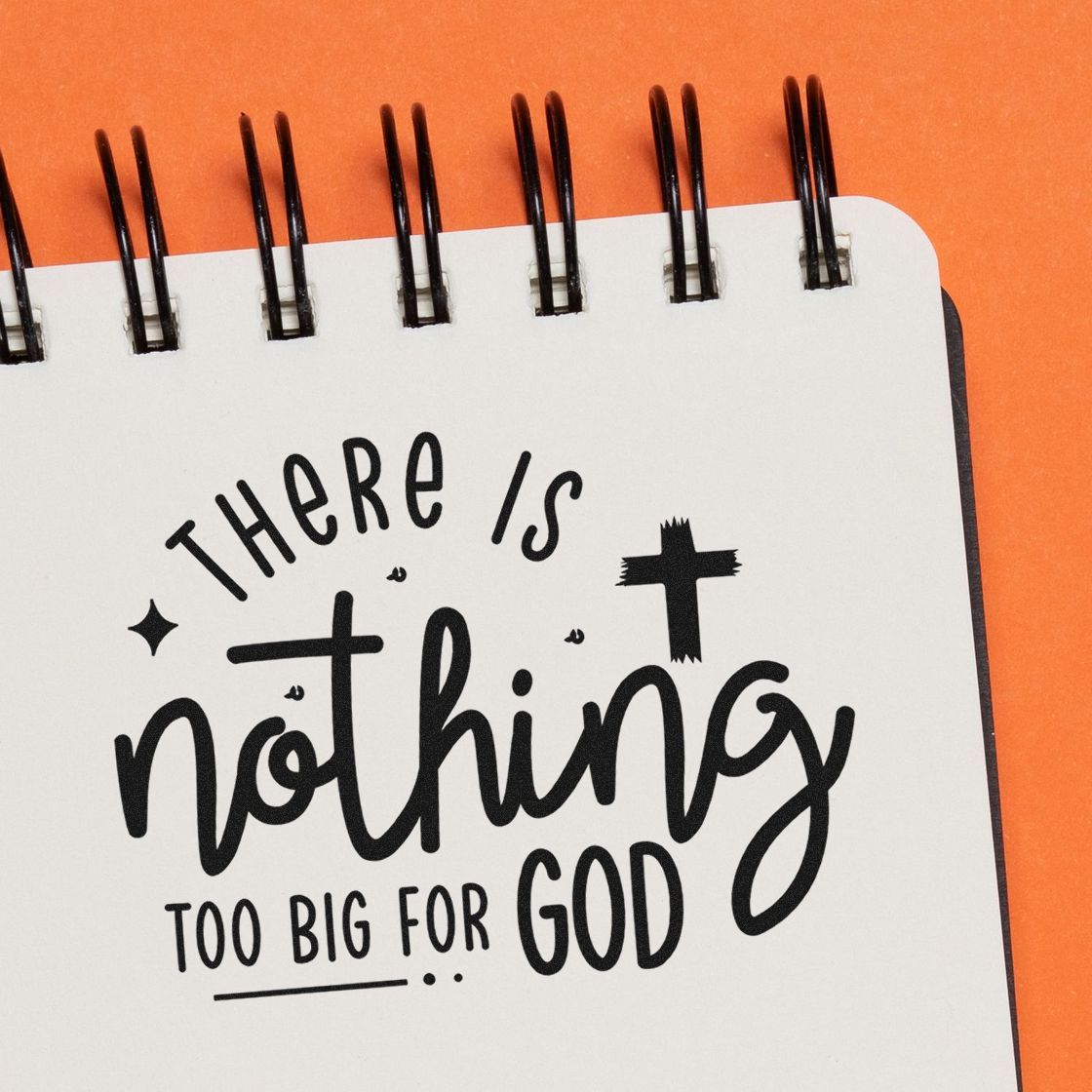 Faith-based rubber stamp design reading There is nothing too big for God on a notebook page.