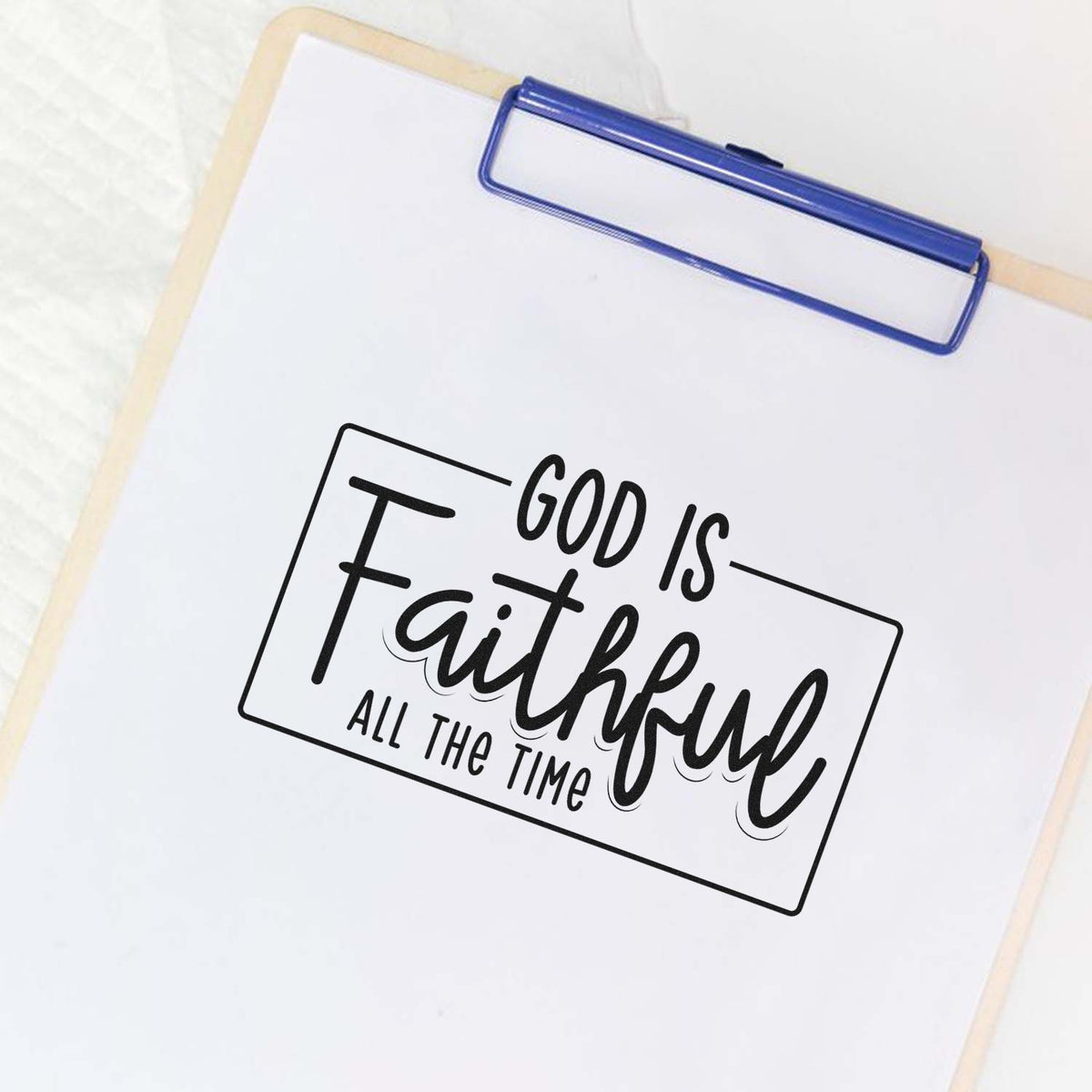 Christian rubber stamp design reading God Is Faithful All the Time on a clipboard page.