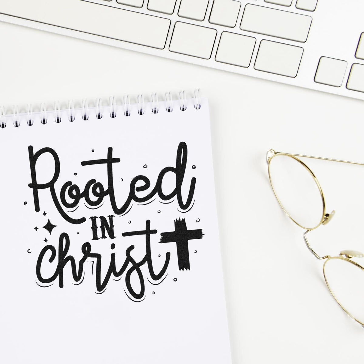 Christian rubber stamp design reading Rooted in Christ on a notebook mockup, ideal for faith-based journaling and planners.