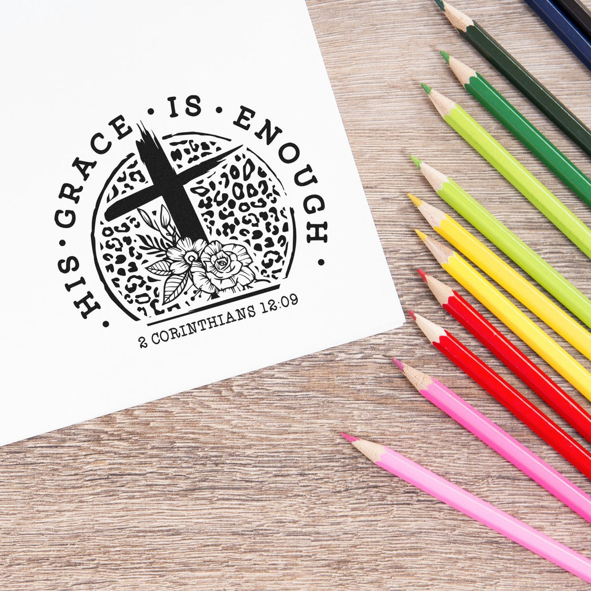 Christian rubber stamp reading Grace Is Enough with 2 Corinthians 12:9, stamped on paper beside colored pencils.