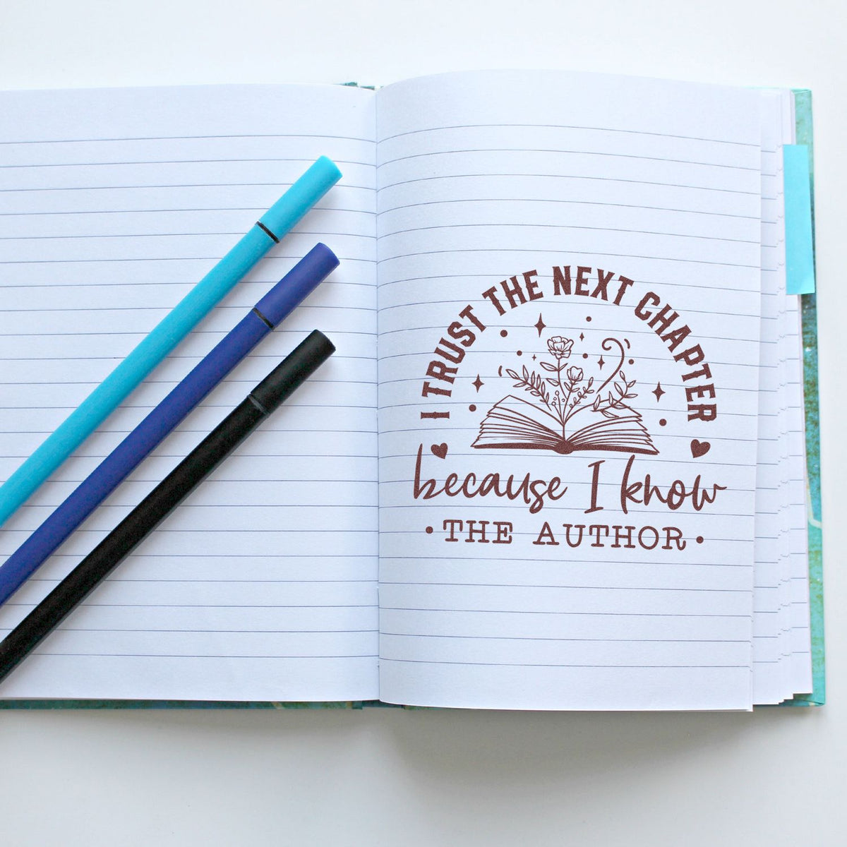 Inspirational rubber stamp for journaling: I trust the next chapter because I know the author with book and floral design.