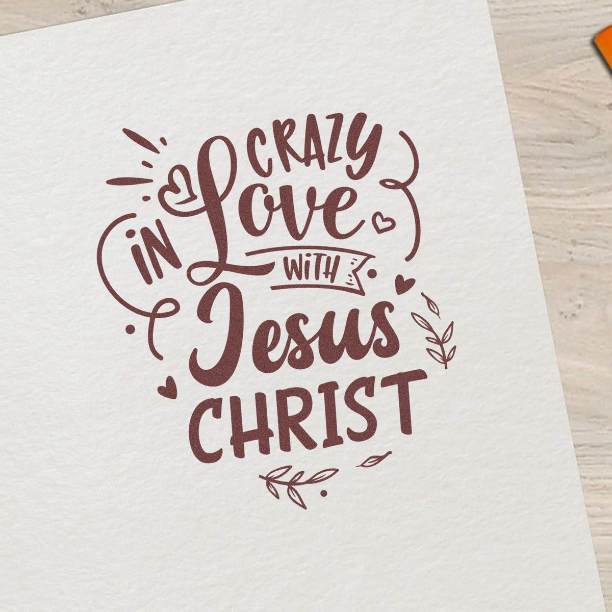 Christian rubber stamp design reading Crazy in Love with Jesus Christ with hearts and floral accents on paper.