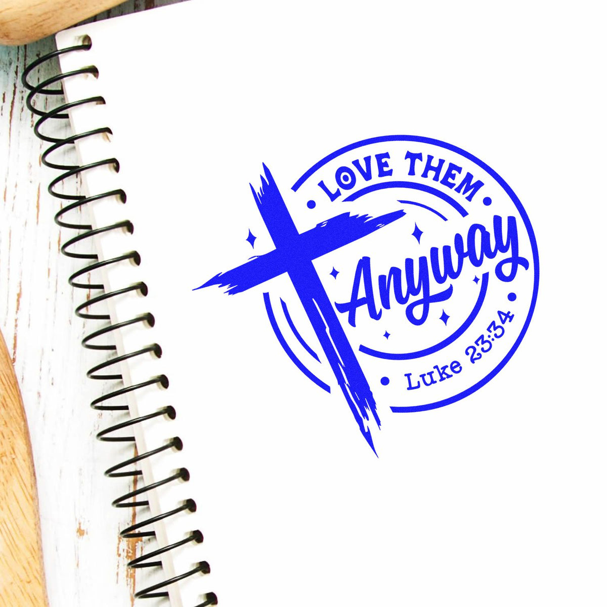 Christian rubber stamp design with cross and Love Them Anyway Luke 23:34 on a notebook page