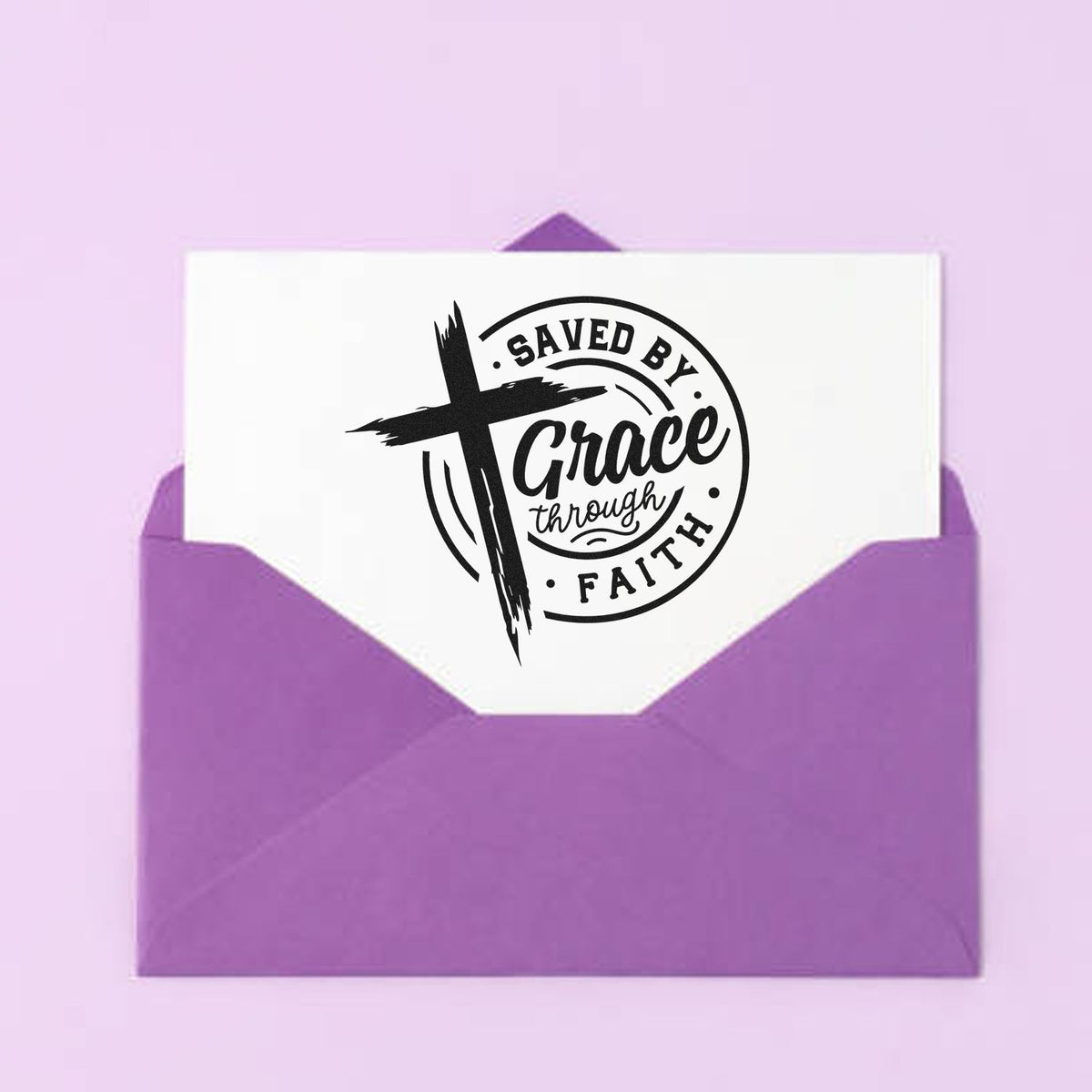 Purple envelope with Saved by Grace Through Faith Christian rubber stamp design featuring a bold cross logo.