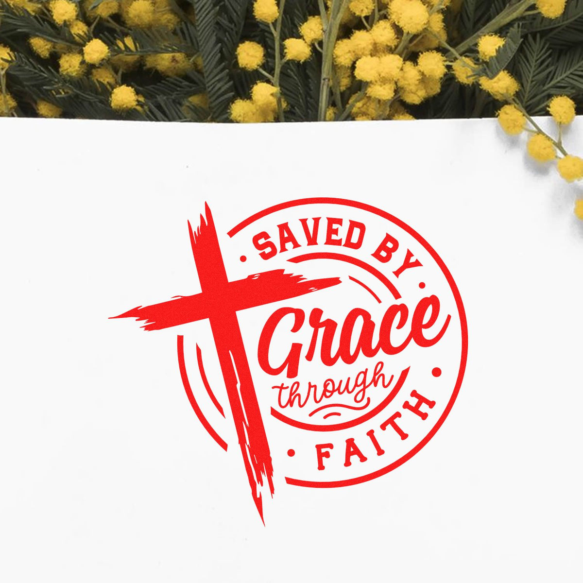 Red Christian rubber stamp design reading Saved by Grace Through Faith with cross graphic on white background.