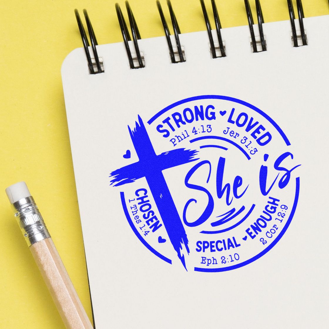 Custom Christian rubber stamp impression on notebook reading She is strong, loved, chosen, special, enough with Bible verses.