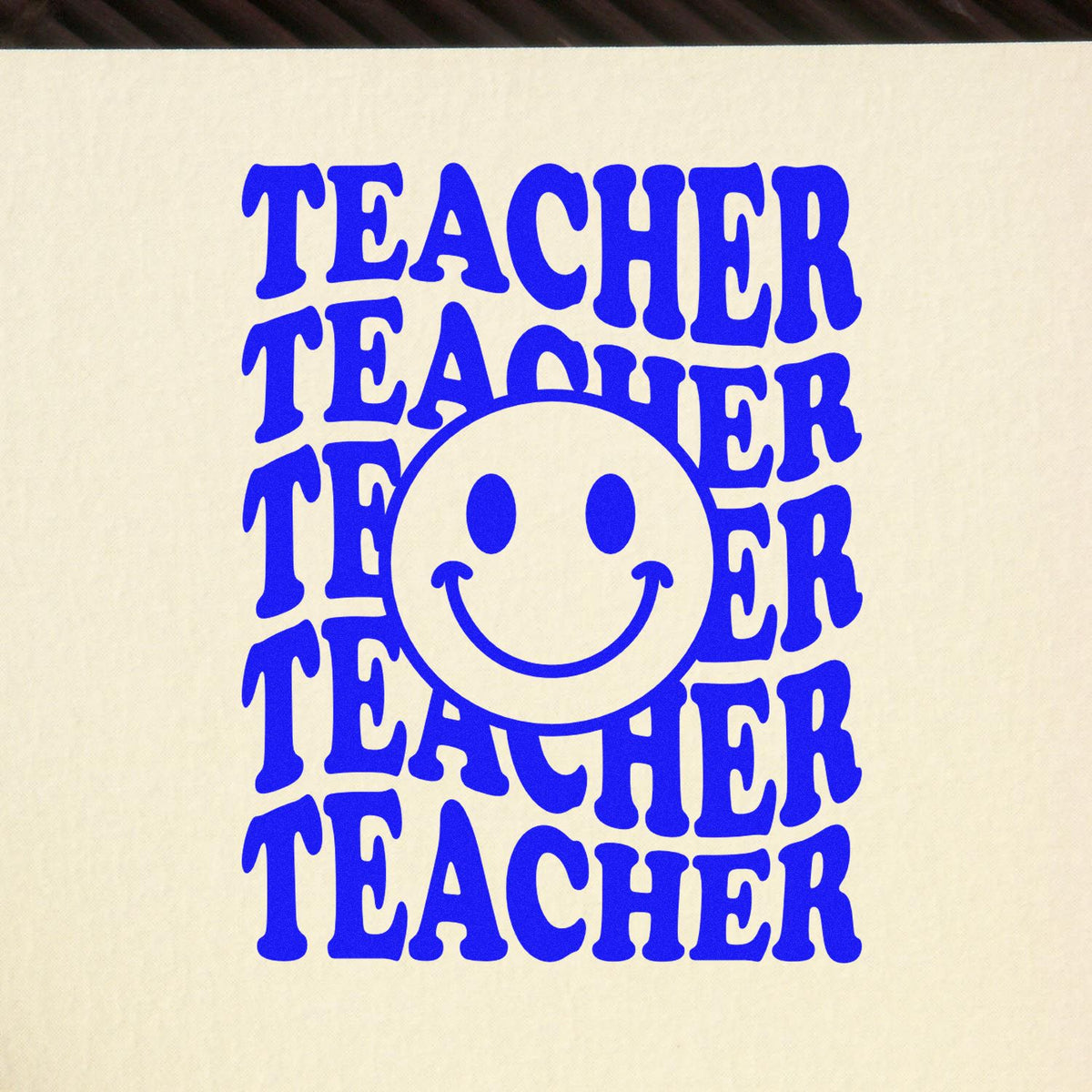 Teacher appreciation rubber stamp design with repeated TEACHER text and a smiling face in bold blue.