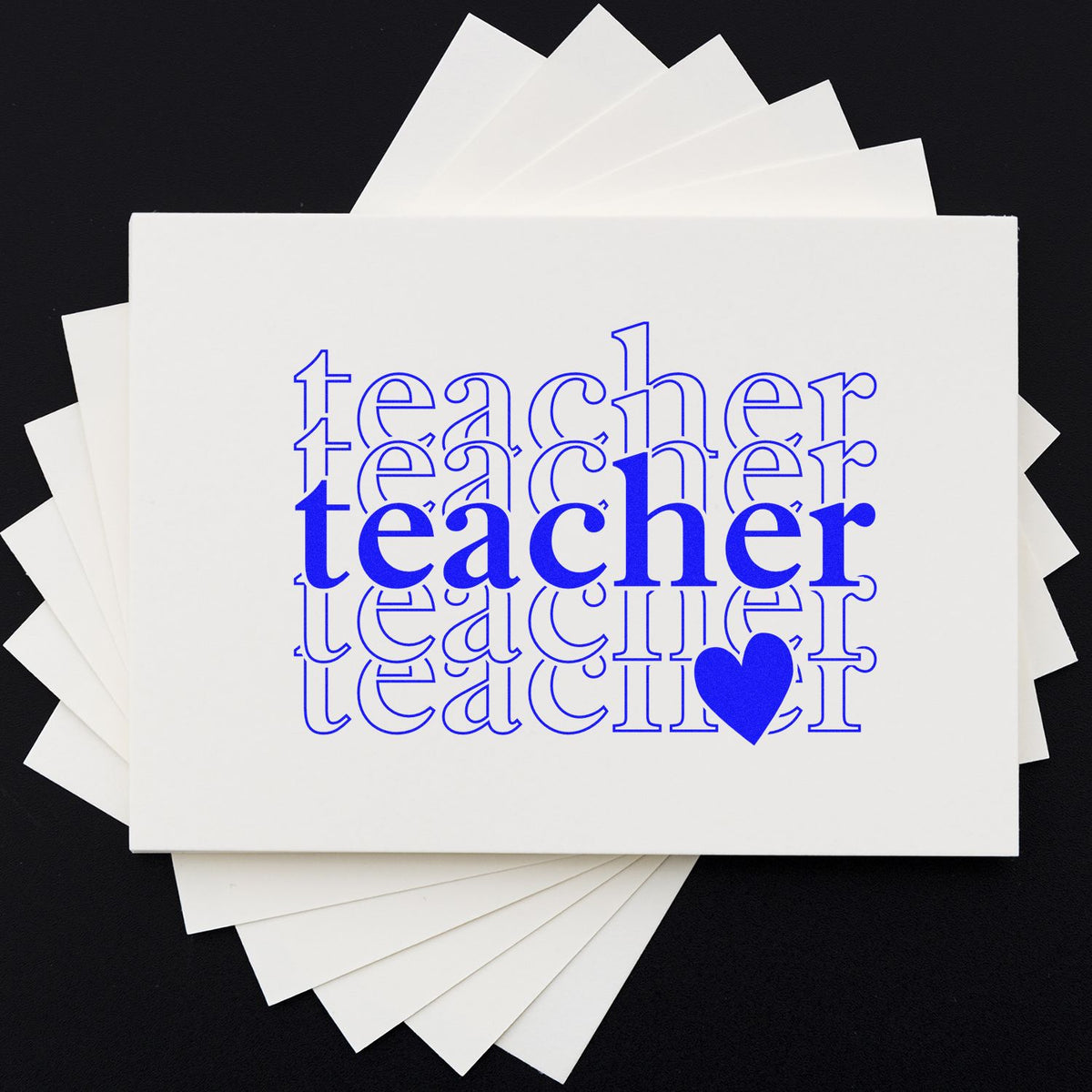 Blue teacher rubber stamp design with heart on stacked white cards for teacher appreciation stationery and craft projects.