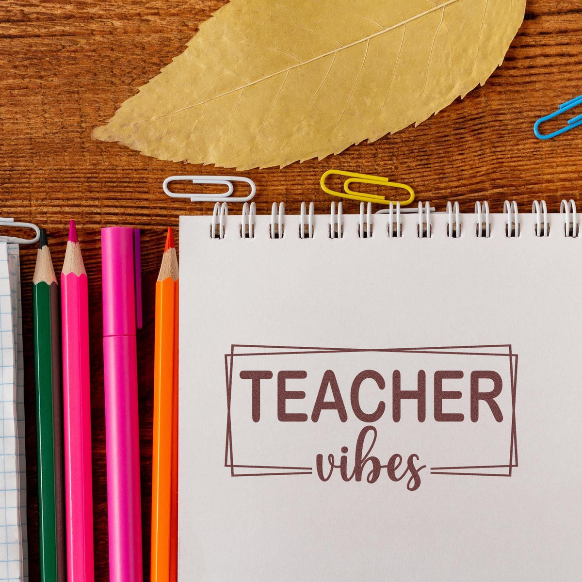 Teacher Vibes rubber stamp on notebook with pencils and leaf for classroom crafts, planner decor, and teacher gifts.