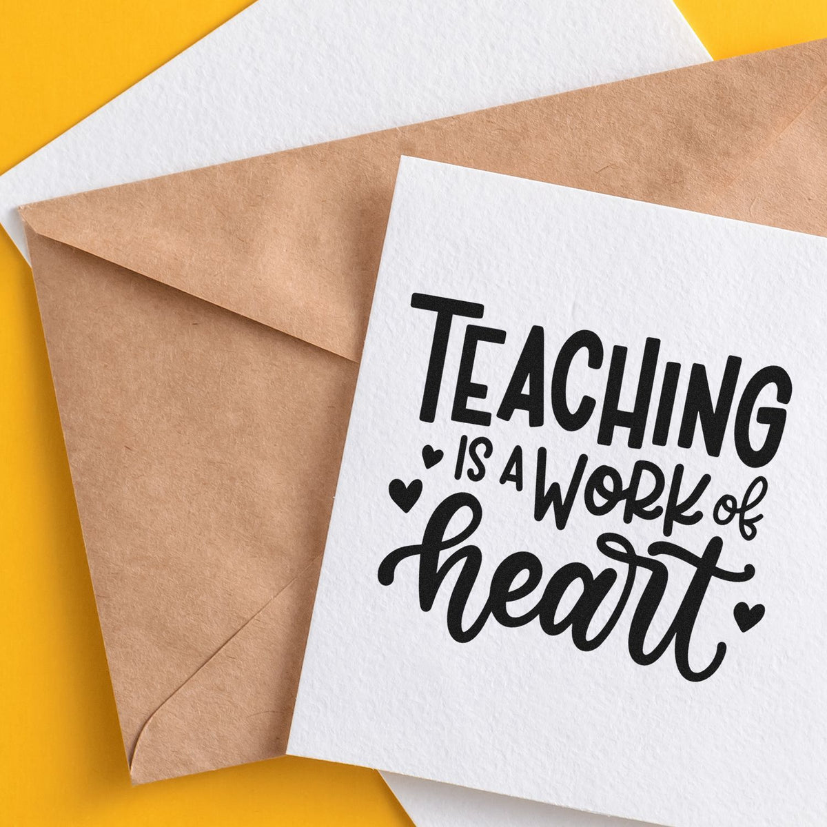 Teacher appreciation rubber stamp design reading Teaching is a work of heart on card with kraft envelope.
