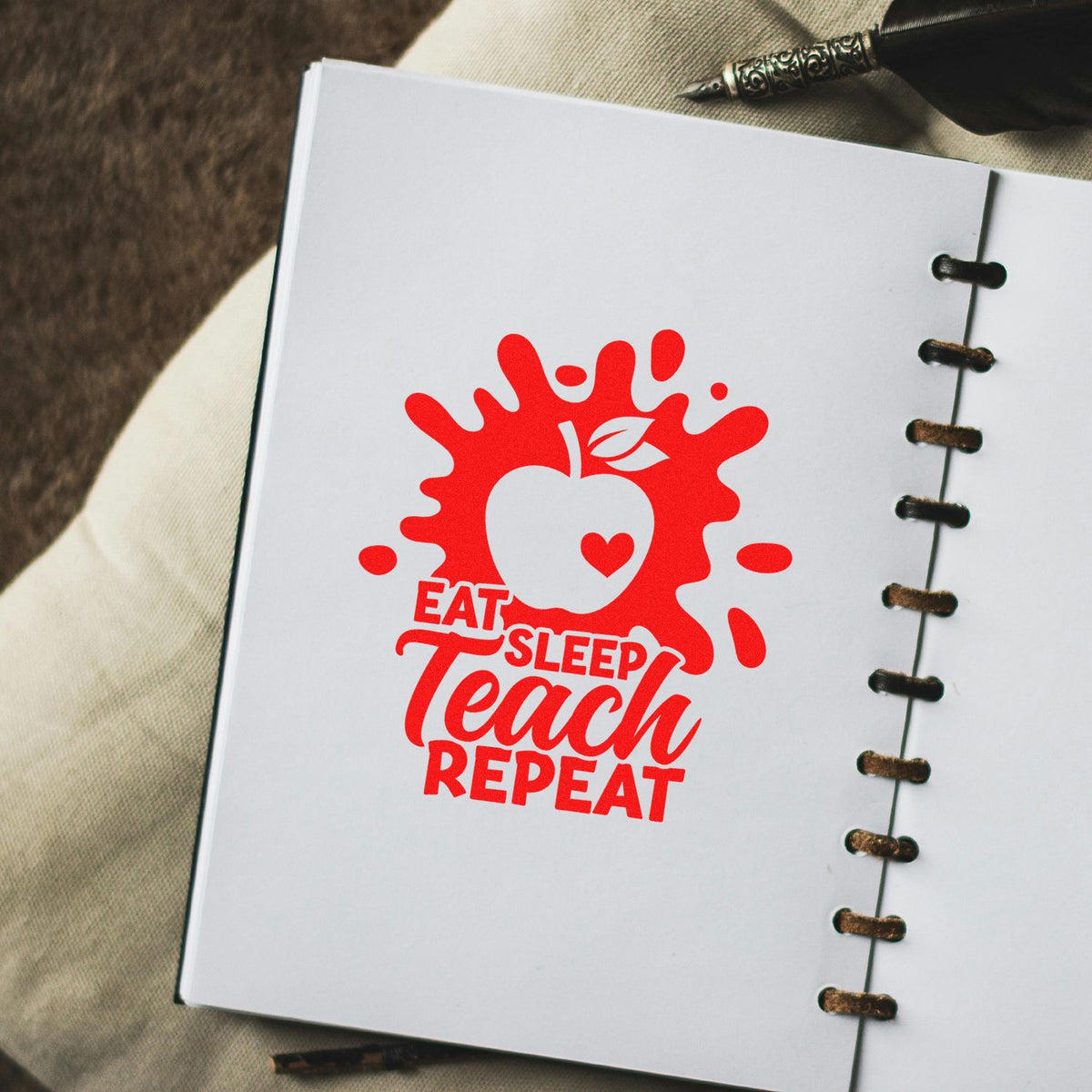 Teacher rubber stamp design on notebook page with red Eat Sleep Teach Repeat apple graphic.