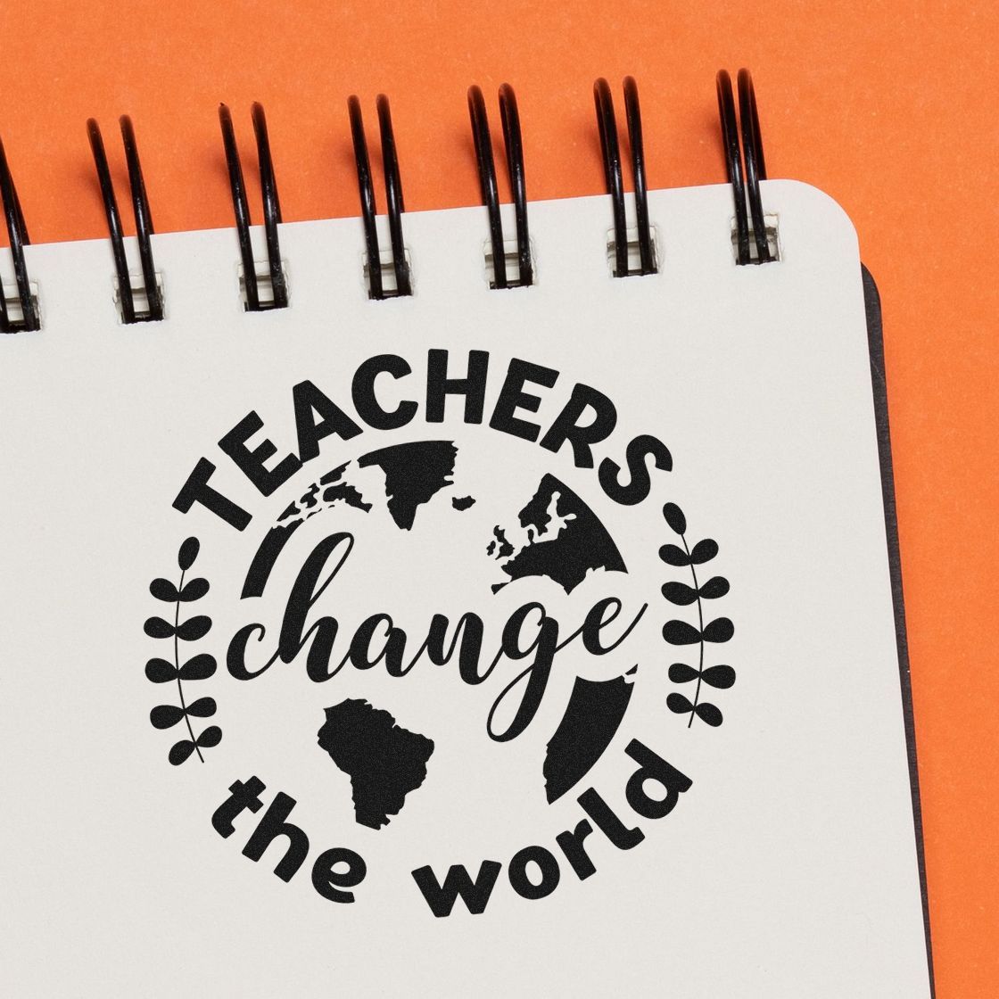 Teachers change the world rubber stamp design on notebook page, featuring globe and leaves for teacher appreciation projects.
