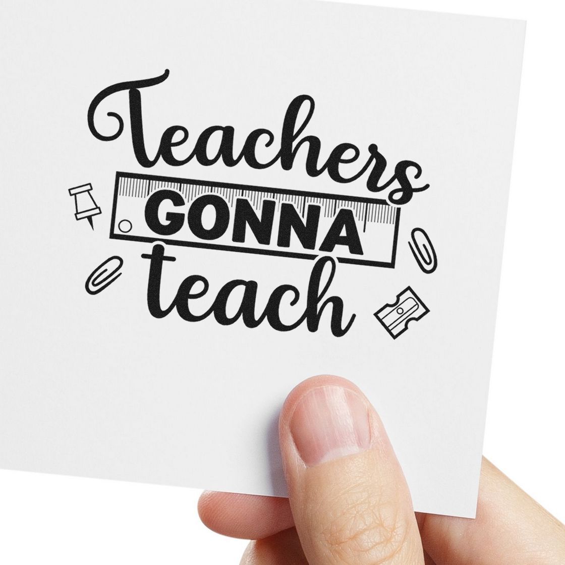 Teachers Gonna Teach rubber stamp design with school supply icons, shown on white paper held in hand.