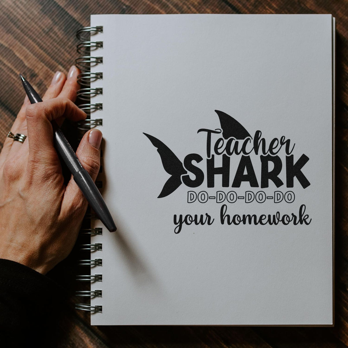 Teacher Shark rubber stamp design on notebook, perfect for marking homework with a fun classroom message.