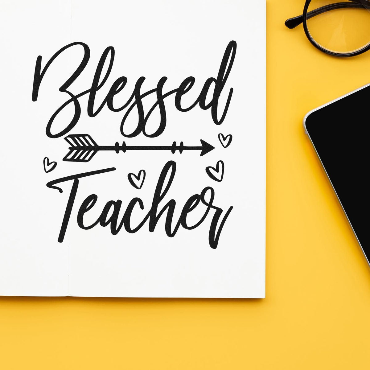 Blessed Teacher rubber stamp design with hearts and arrow, displayed on a notebook for classroom gifting.
