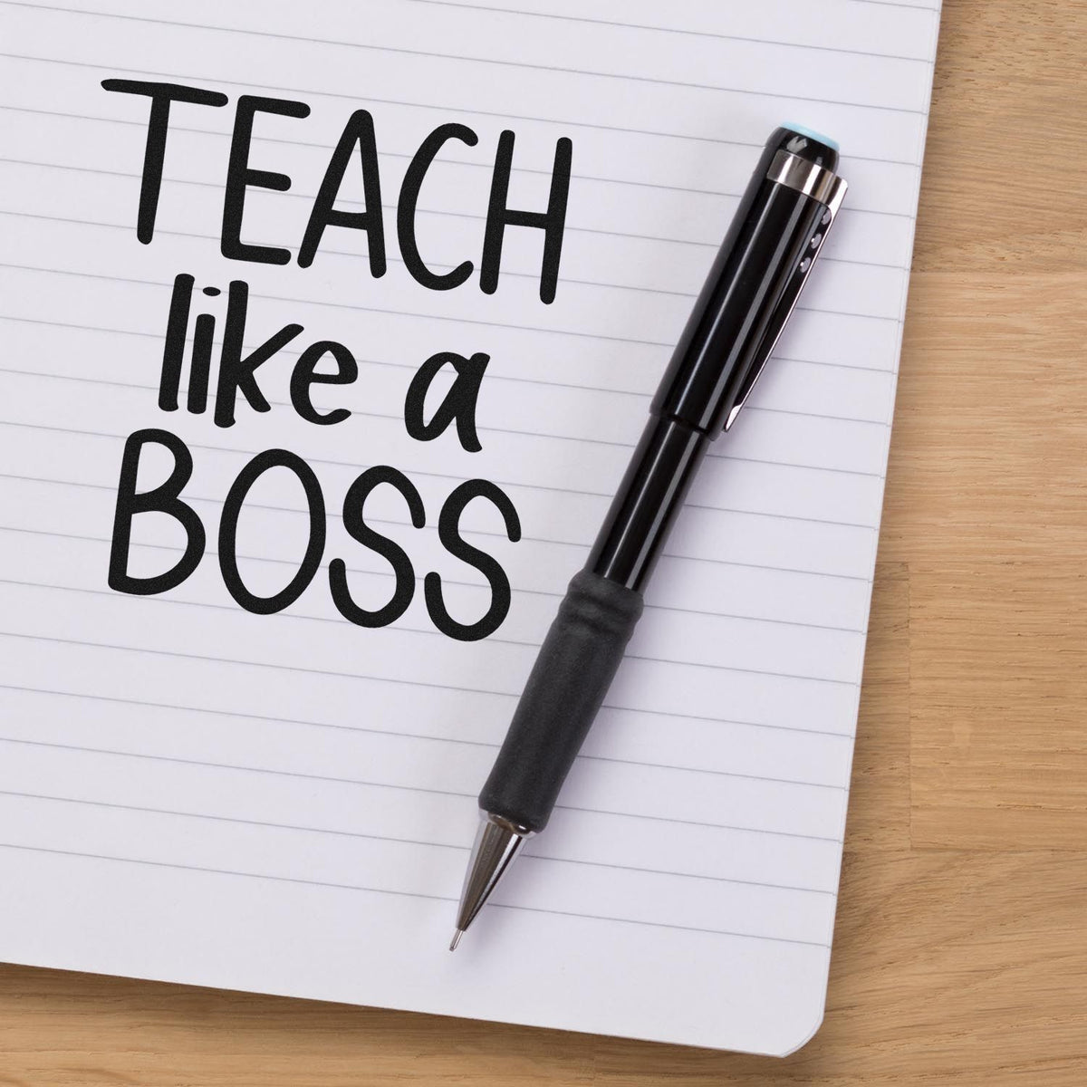 Teach like a boss rubber stamp impression on a notebook with pen, ideal for teacher rewards, classroom notes, and education branding.