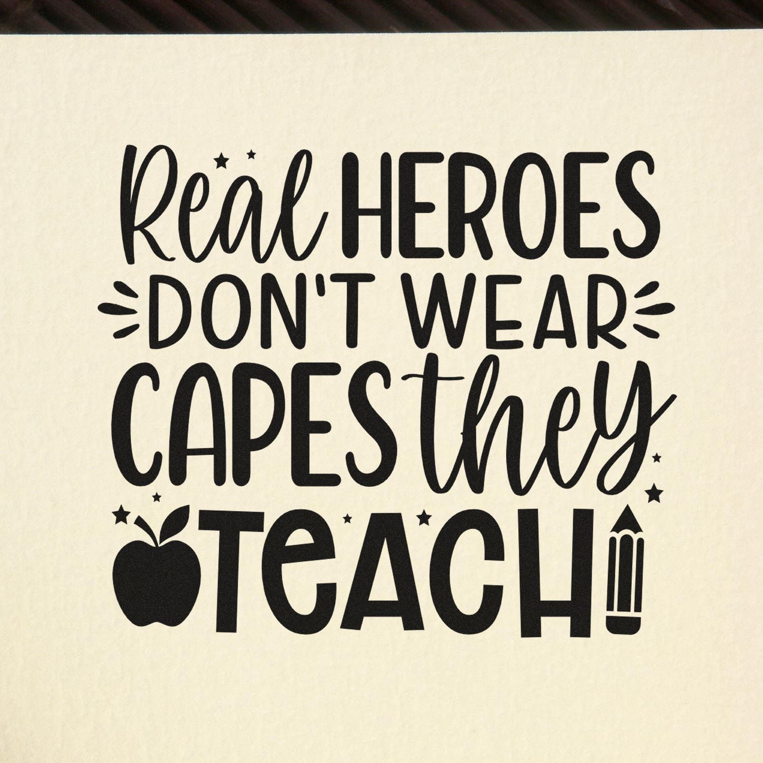 Teacher appreciation rubber stamp design reading Real heroes dont wear capes, they teach with apple and pencil icons.