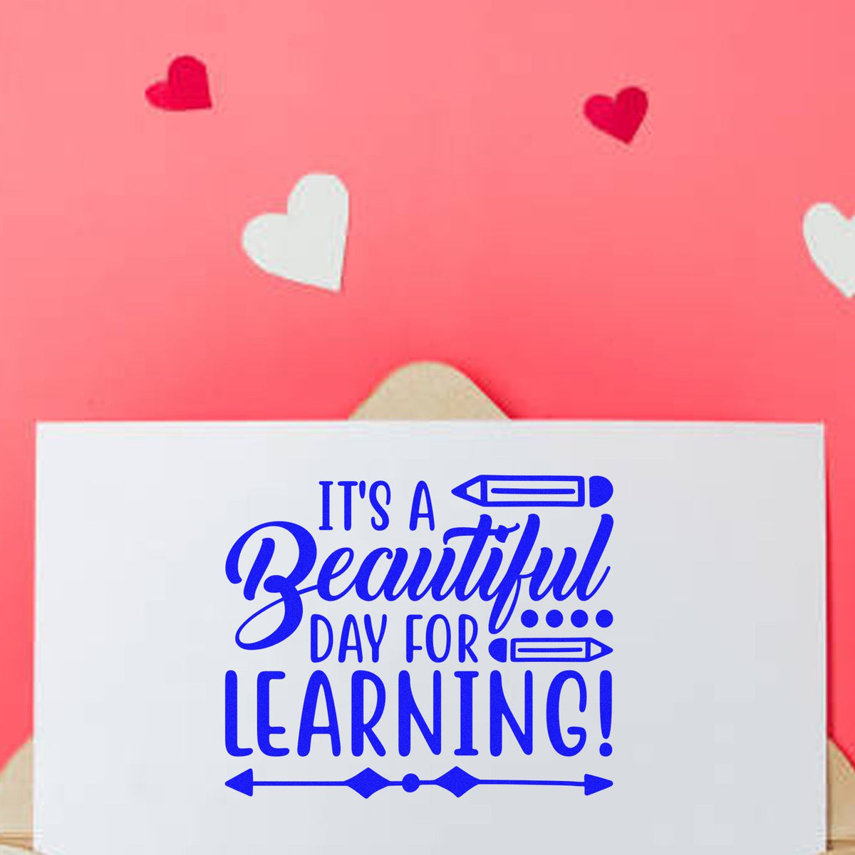 Decorative rubber stamp design with Its a Beautiful Day for Learning! text, blue lettering, and heart accents.