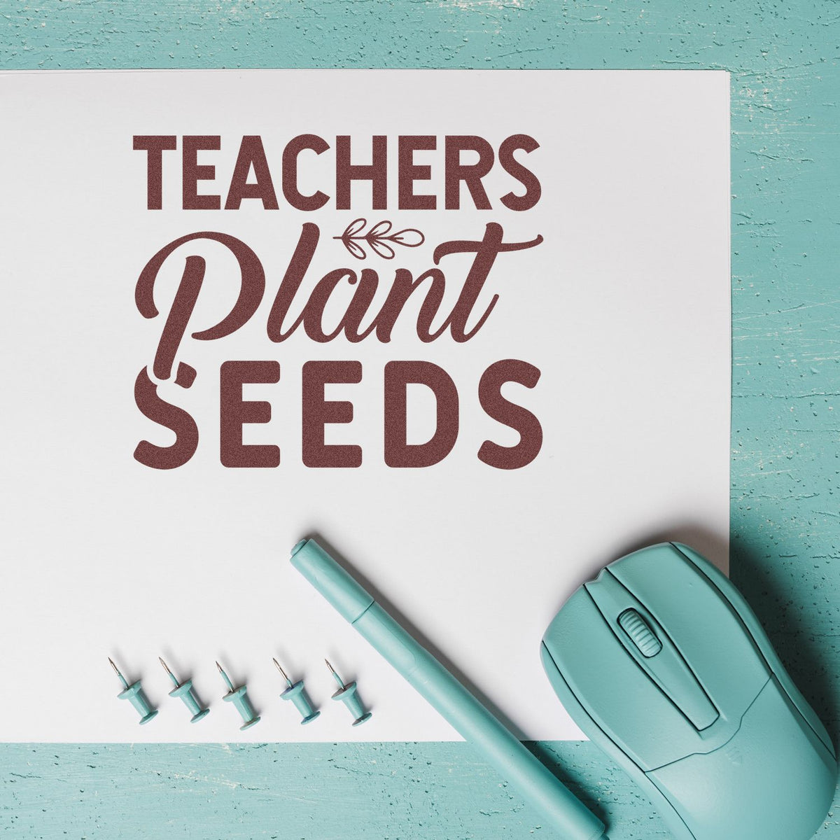 Teachers Plant Seeds rubber stamp for teacher appreciation crafts, with teal stamp tools on a desk.