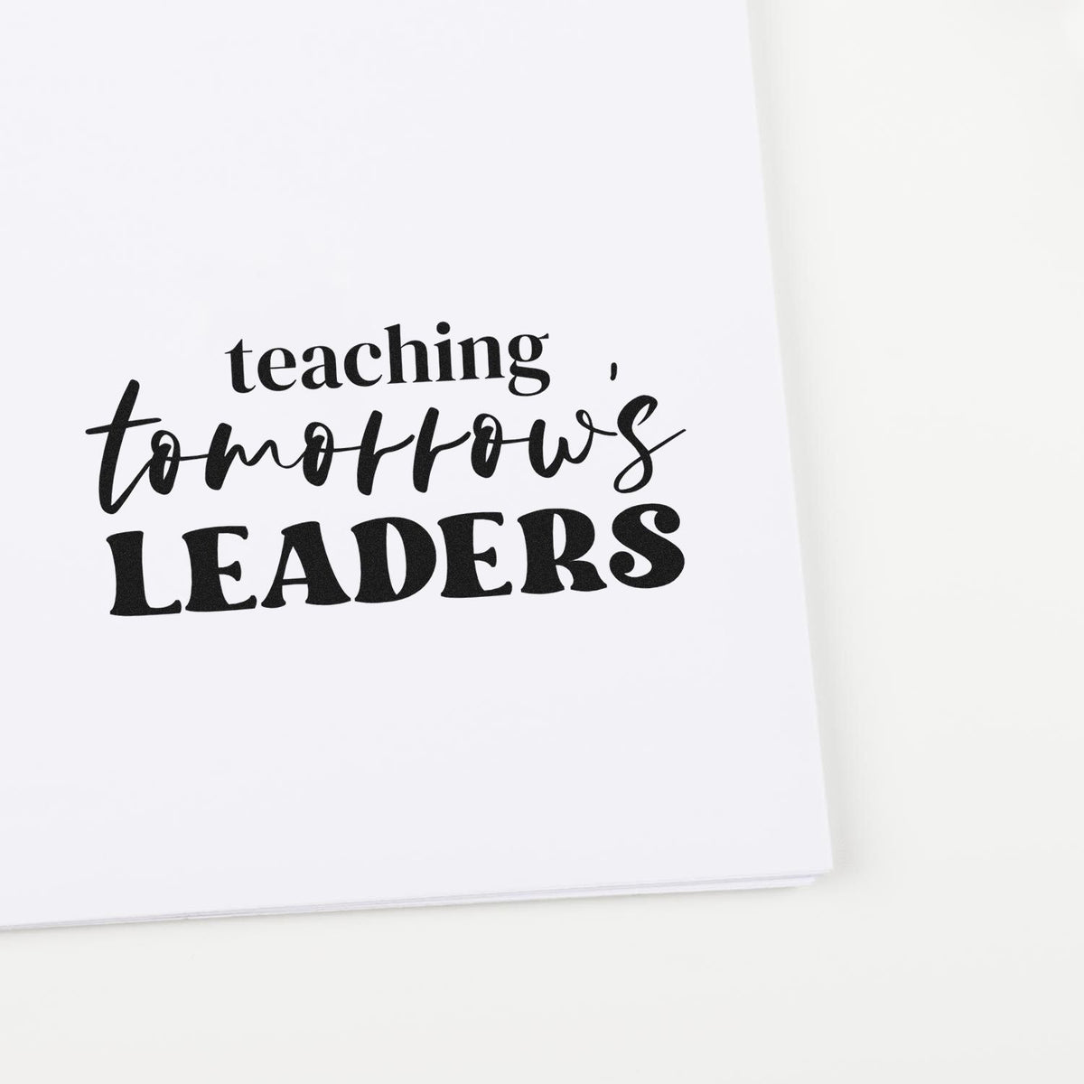 Teaching Tomorrows Leaders rubber stamp on white paper, ideal for teacher appreciation and classroom projects.