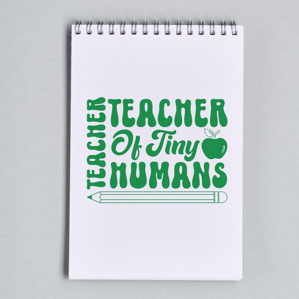 Teacher of Tiny Humans rubber stamp design in green with apple and pencil on notebook page