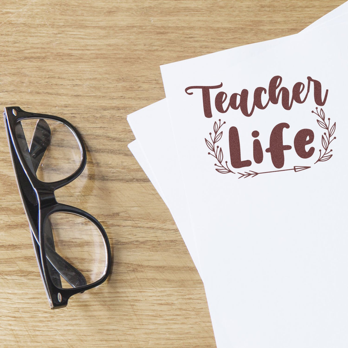 Teacher Life rubber stamp impression on paper beside eyeglasses, ideal for classroom crafts and teacher gifts.