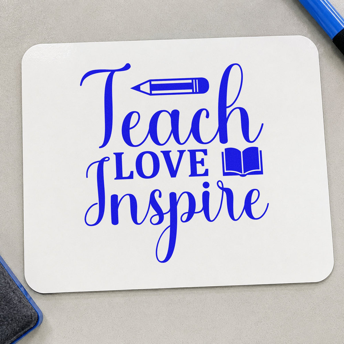 Teach Love Inspire Book craft stamp imprinted in blue ink on paper, a design suited to library card seals.