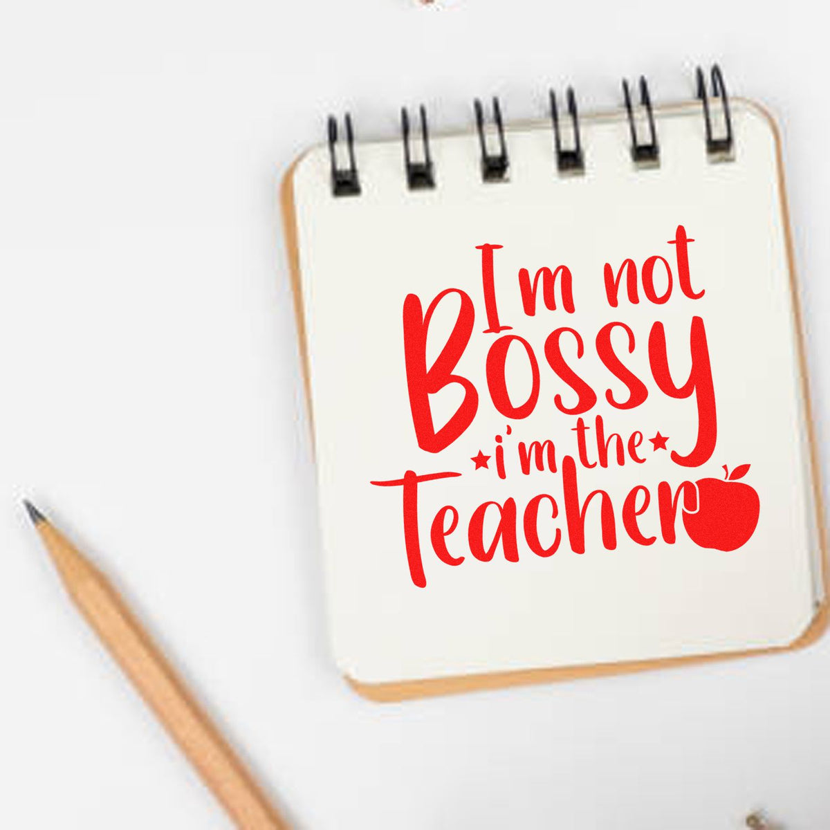 Teacher rubber stamp design reading Im not bossy, Im the teacher with apple icon.