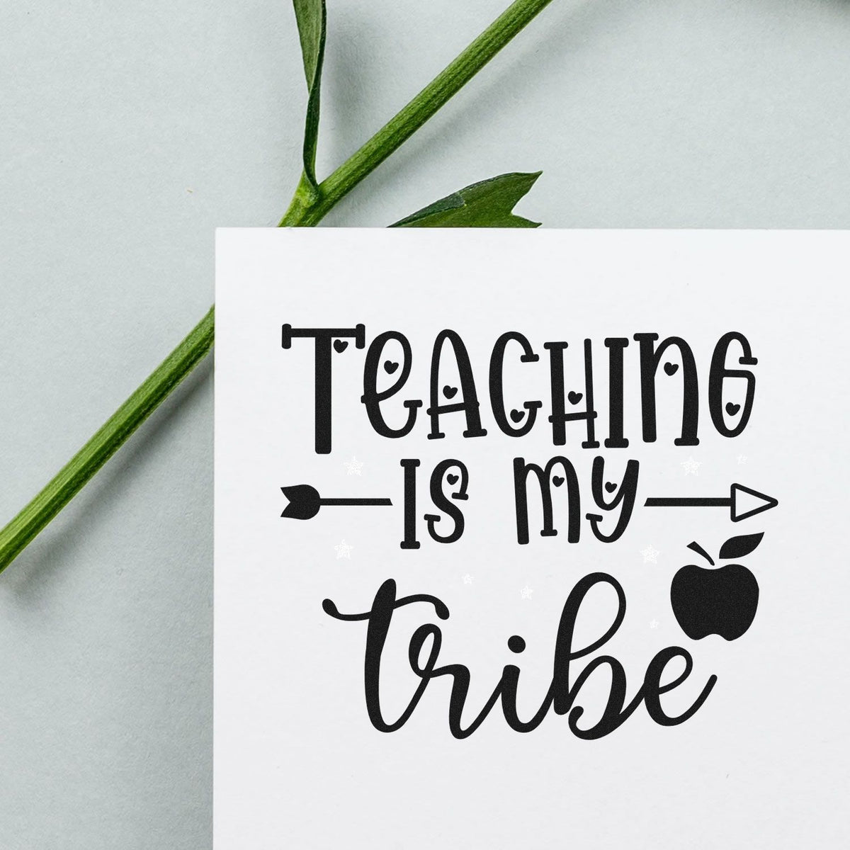 Teacher rubber stamp design with Teaching Is My Tribe text, apple icon and arrow, ideal for classroom crafts and gifts.