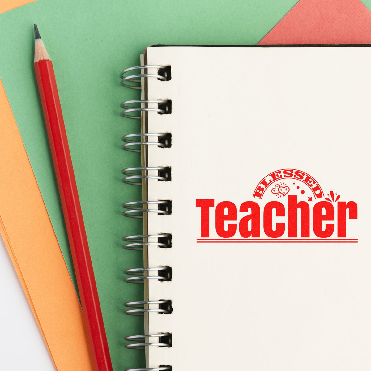 Blessed Teacher rubber stamp design on notebook, with pencil and colorful paper for teacher appreciation projects.