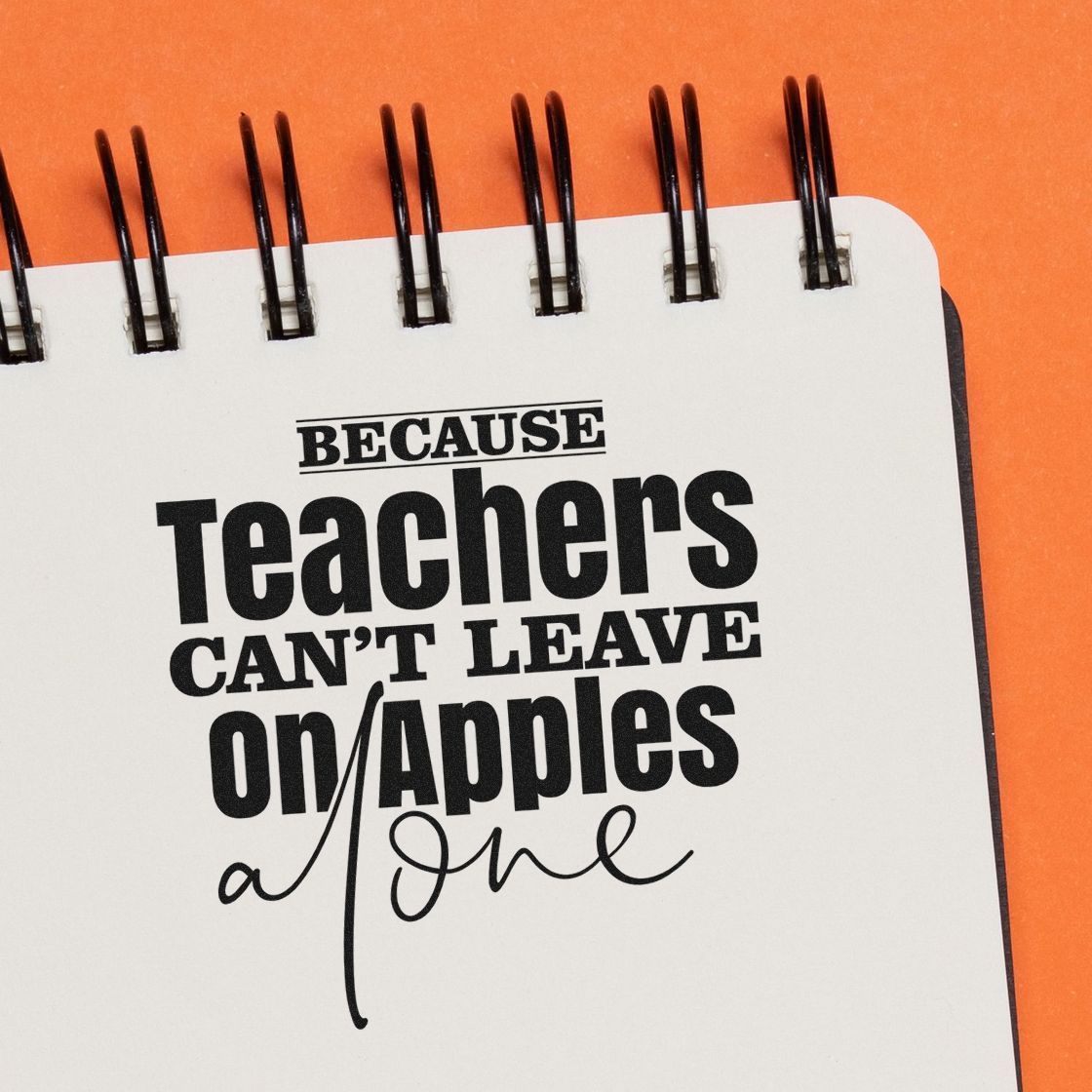 Funny teacher rubber stamp design with quote, Because teachers cant leave on apples alone, shown in a spiral notebook.