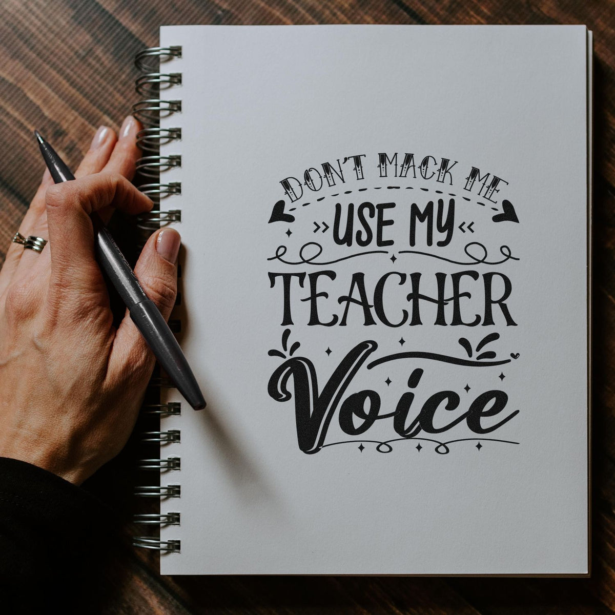 Custom teacher rubber stamp design in a notebook, reading Dont make me use my teacher voice.