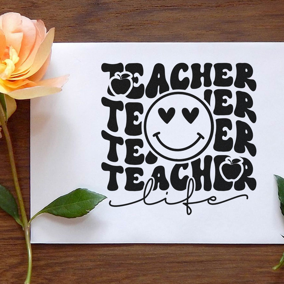 Teacher life rubber stamp design with smiley face and apple icons, perfect for classroom crafts and teacher gifts.