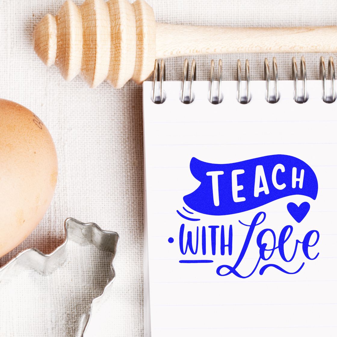 Teach with Love rubber stamp design on notebook, perfect for teacher appreciation crafts and classroom stationery.