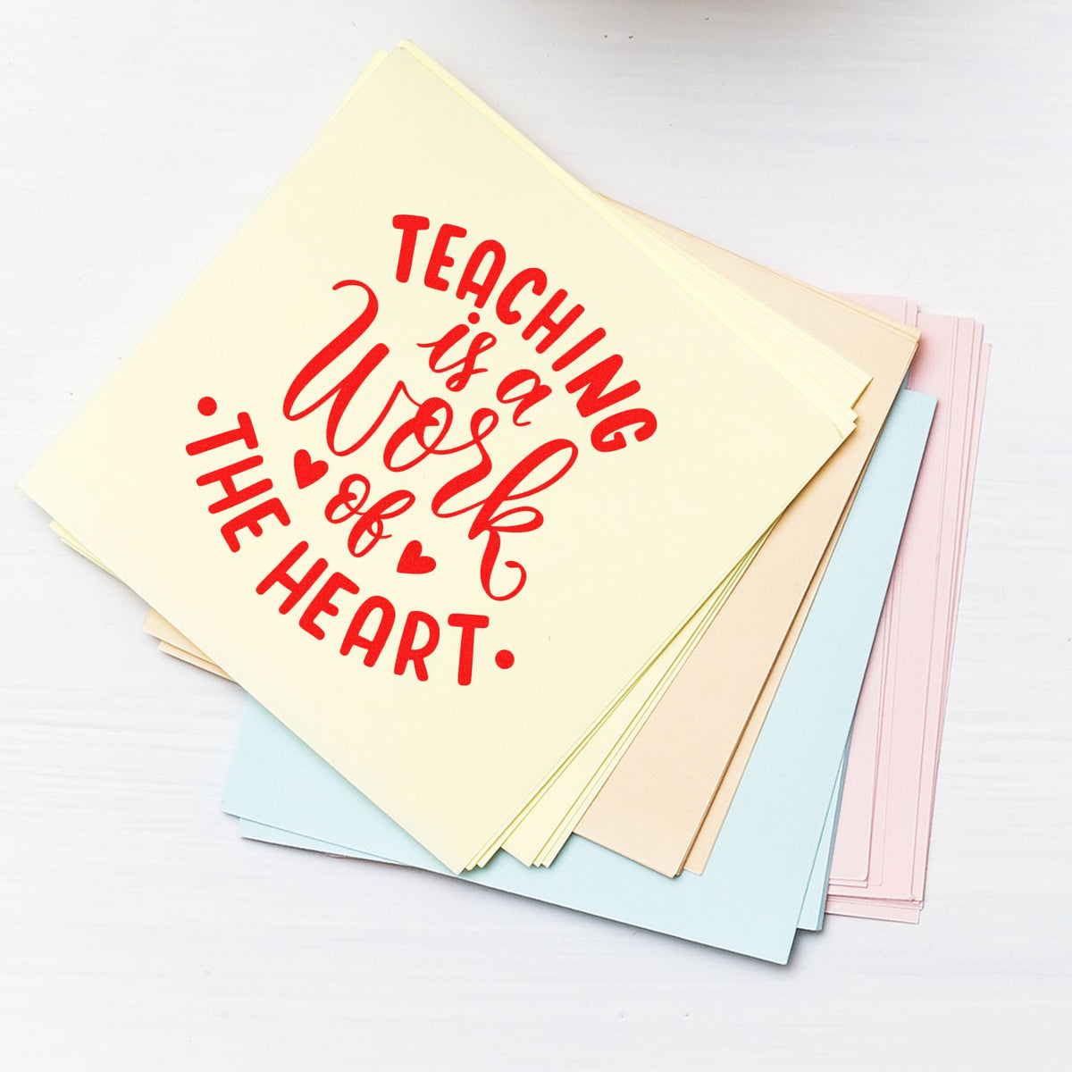 Teaching is a work of the heart rubber stamp design on pastel paper stack, ideal for teacher appreciation crafts.