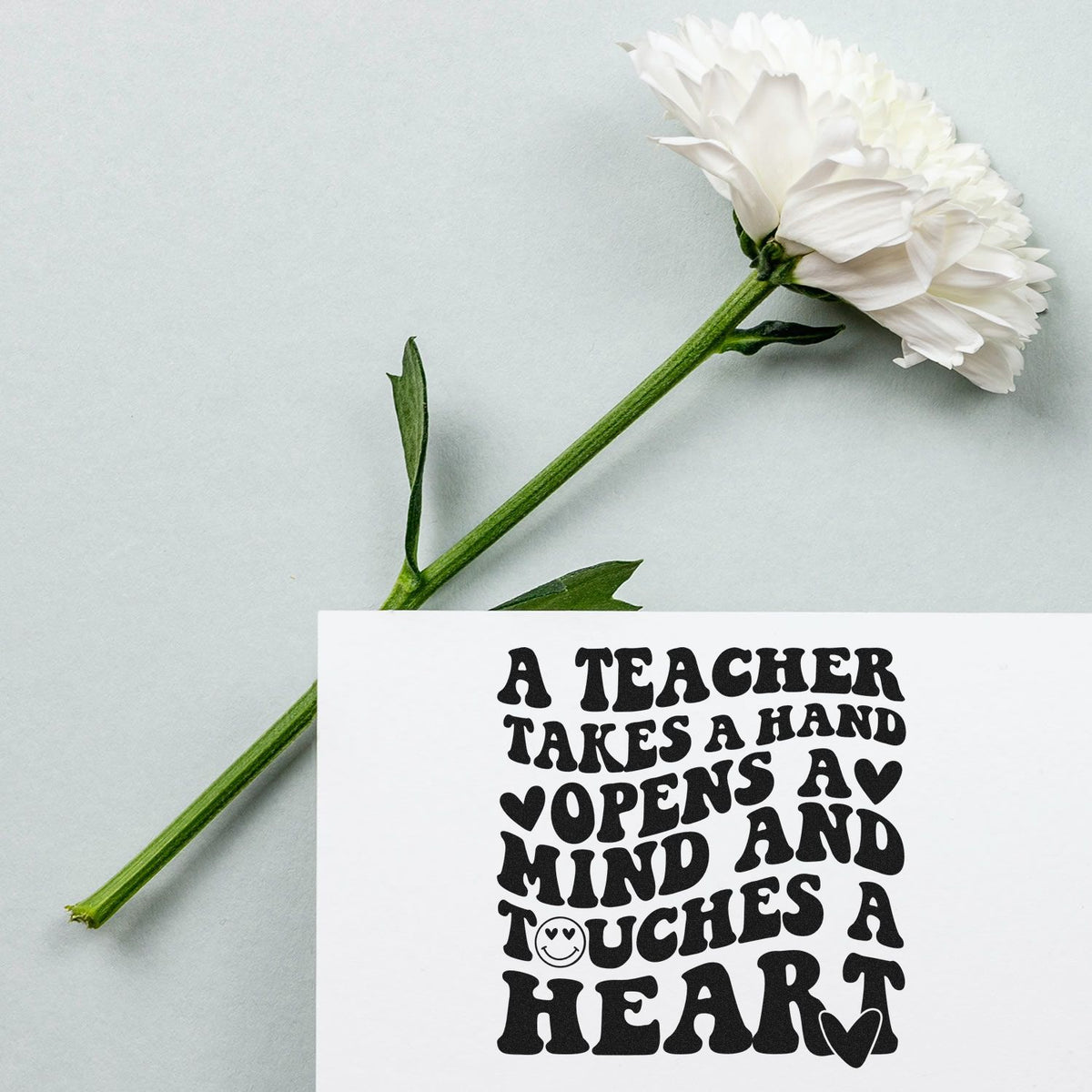Teacher appreciation rubber stamp with quote A teacher takes a hand, opens a mind and touches a heart beside a white flower.