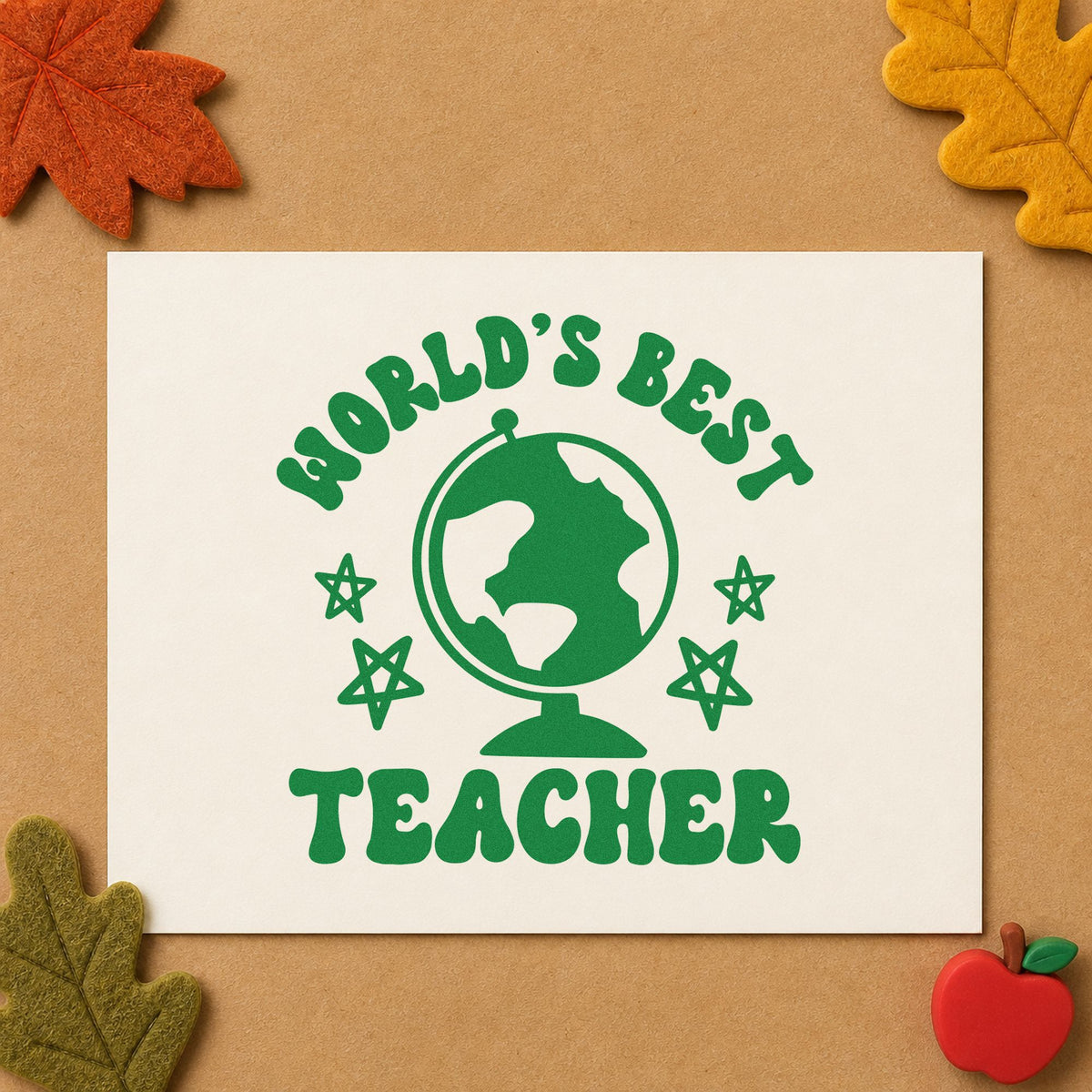 World's Best Teacher Globe craft stamp imprint in green ink on a handmade project, one idea being framed space corner.