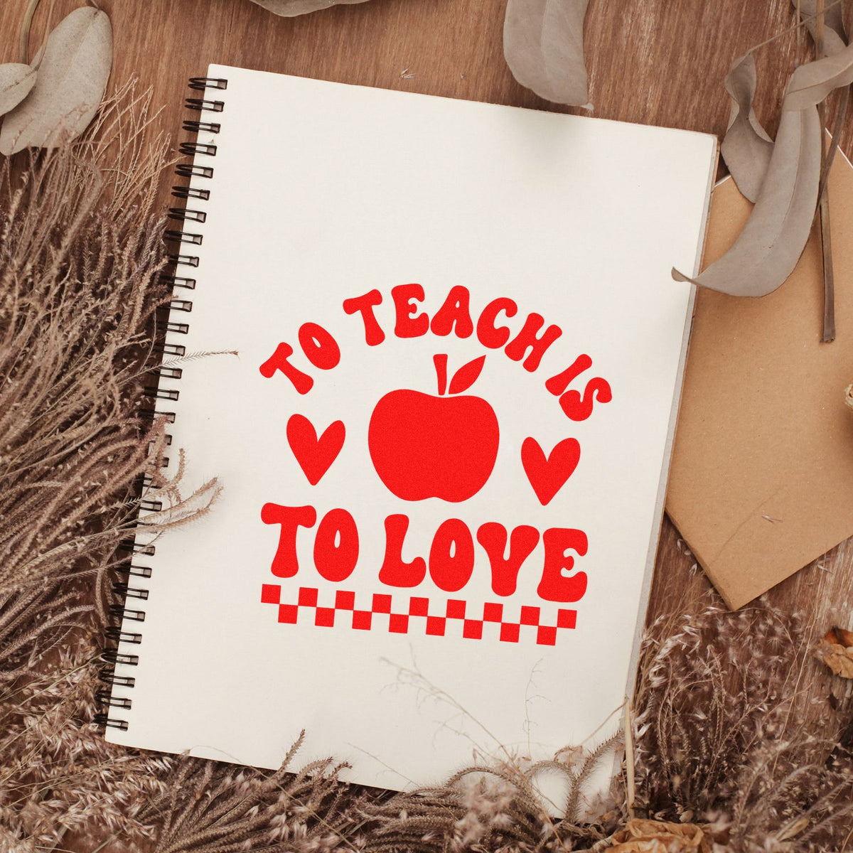 Teacher appreciation rubber stamp design with To Teach Is To Love apple art on a notebook, ideal for crafting and journaling.