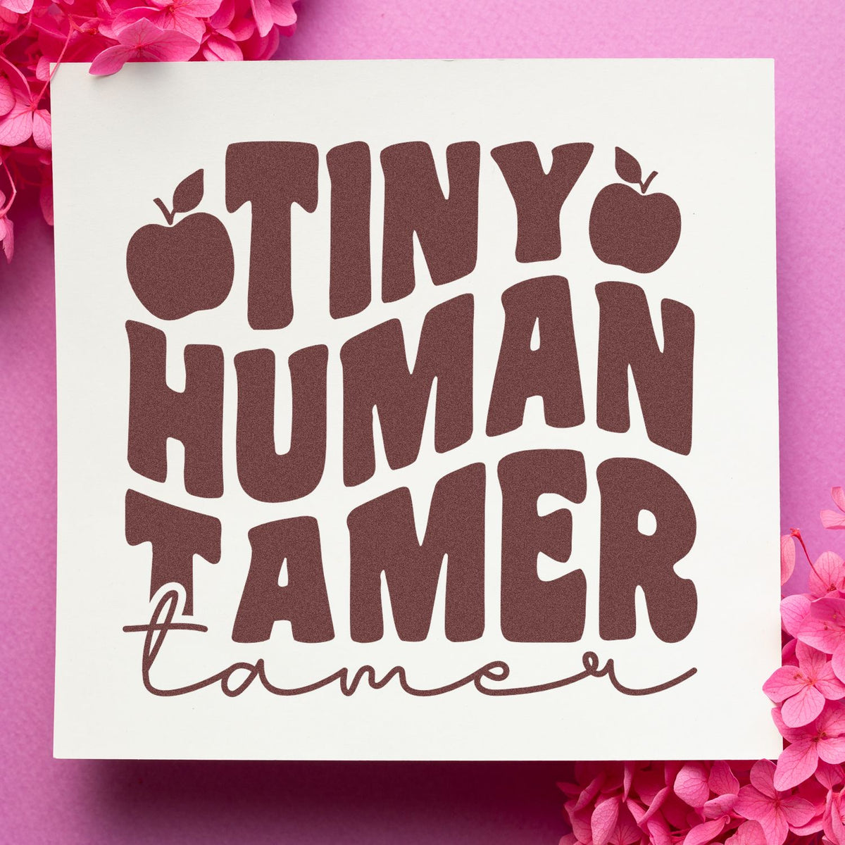 Tiny Human Tamer custom rubber stamp design with bold lettering and apple accents on a pink floral background.