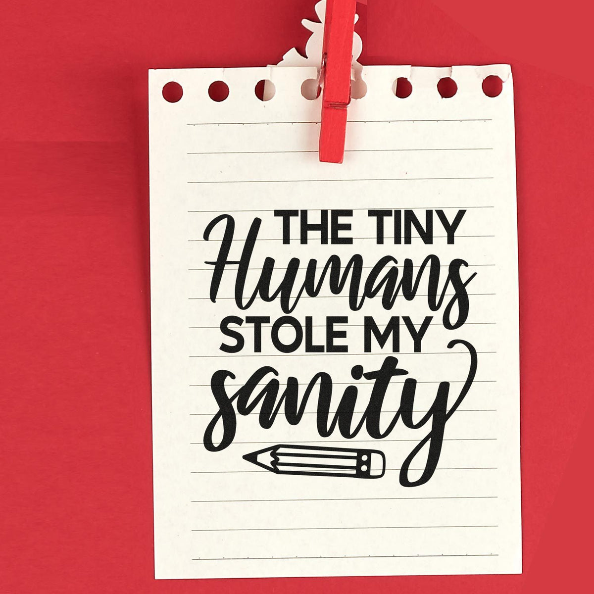 Funny rubber stamp design with the quote The Tiny Humans Stole My Sanity on lined paper, clipped with a red clothespin.