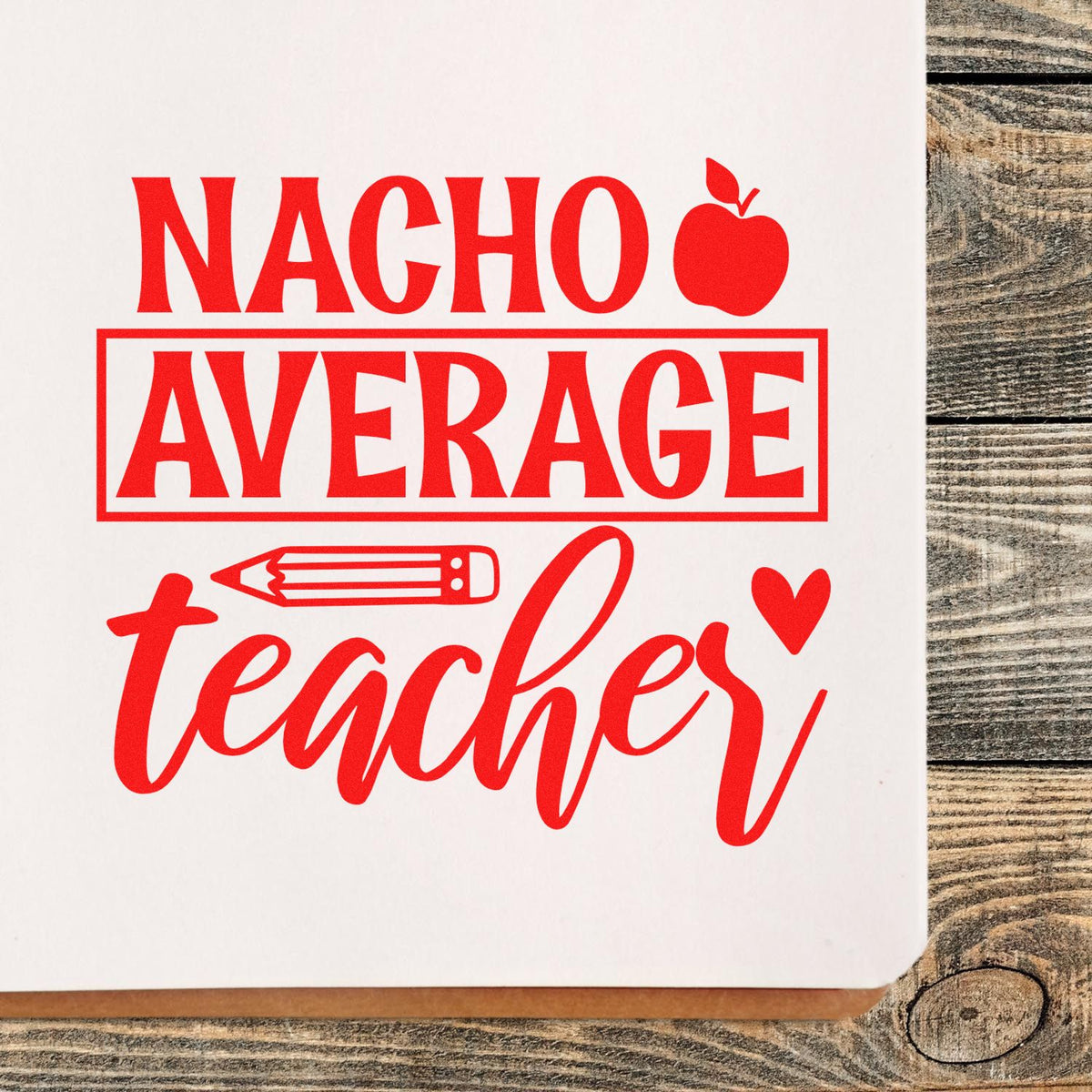 Red Nacho Average Teacher rubber stamp design with apple, pencil, and heart accents on white paper.