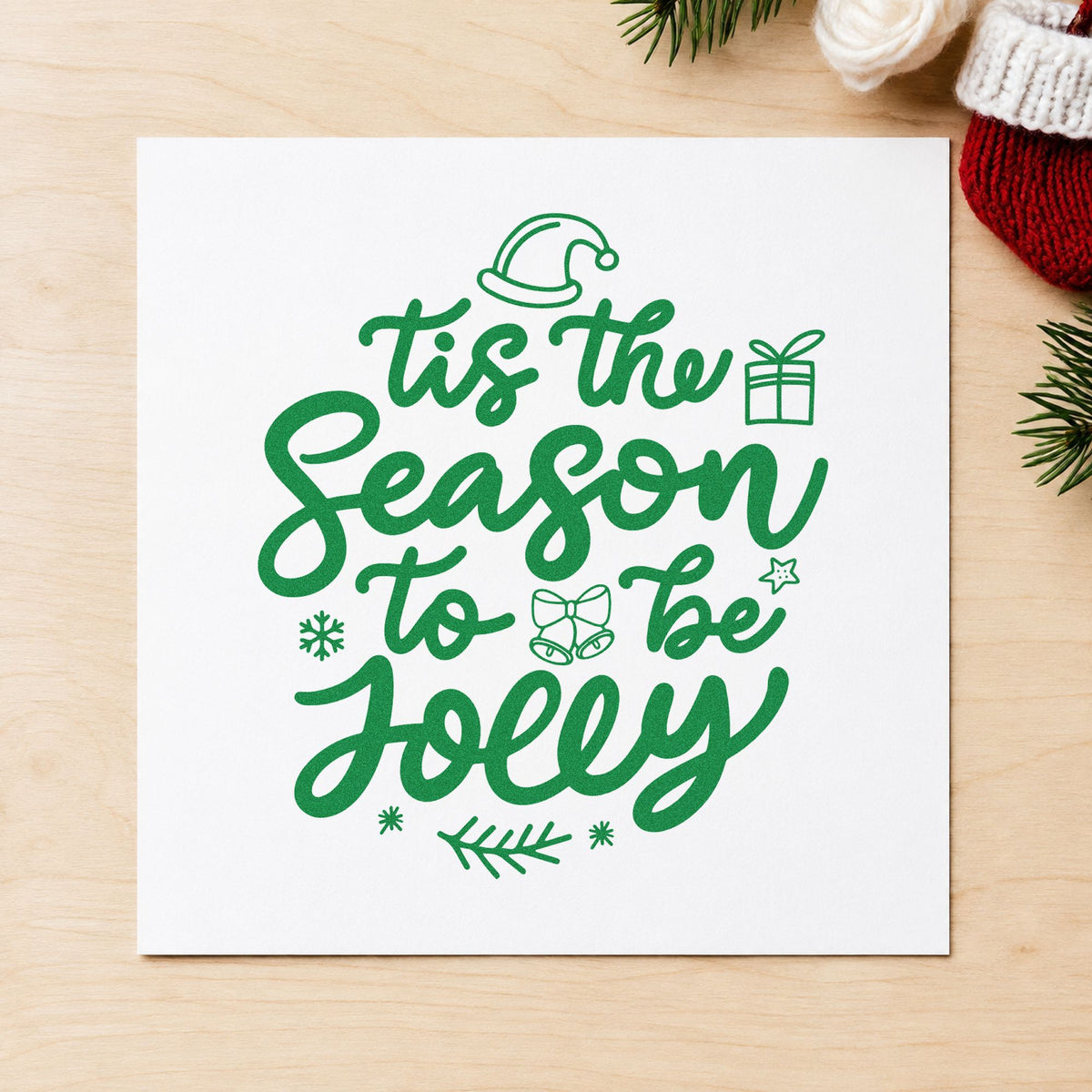 Tis Season To Be Jolly craft stamp imprinted in green ink on paper, a design suited to cracker tube seals.