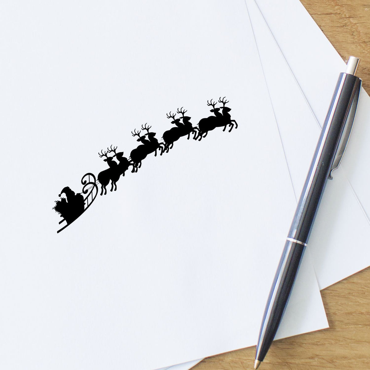 Reindeer And Santa Sleigh Scene PSI Pre-Inked Stamp imprint stamped in black ink. A silhouette of Santa's sleigh is pulled upward by a team of flying reindeer.