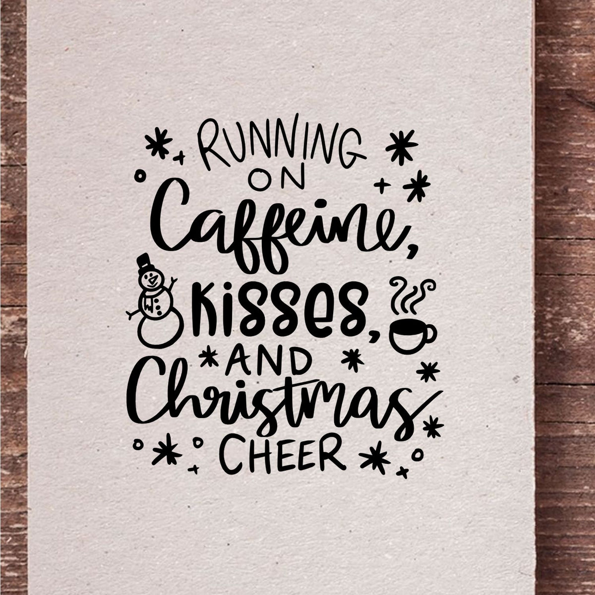 Caffeine Kisses Christmas Cheer Pre-Inked Stamp – Slim imprint stamped in black ink. “Running on Caffeine, Kisses and Christmas Cheer” is surrounded by a snowman, coffee cup, hearts, and stars.
