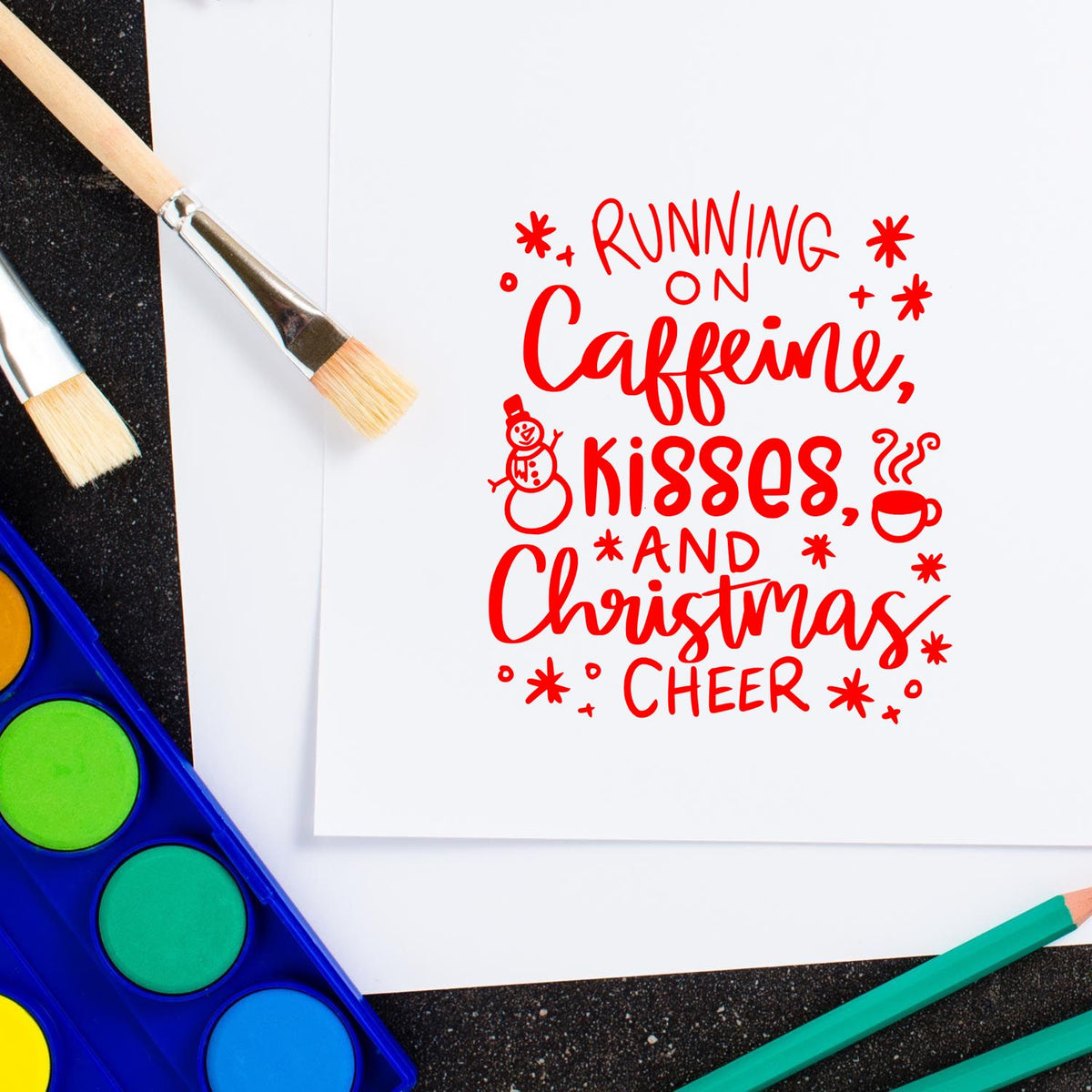Christmas rubber stamp design reading Running on Caffeine, Kisses, and Christmas Cheer with paintbrushes and watercolor.