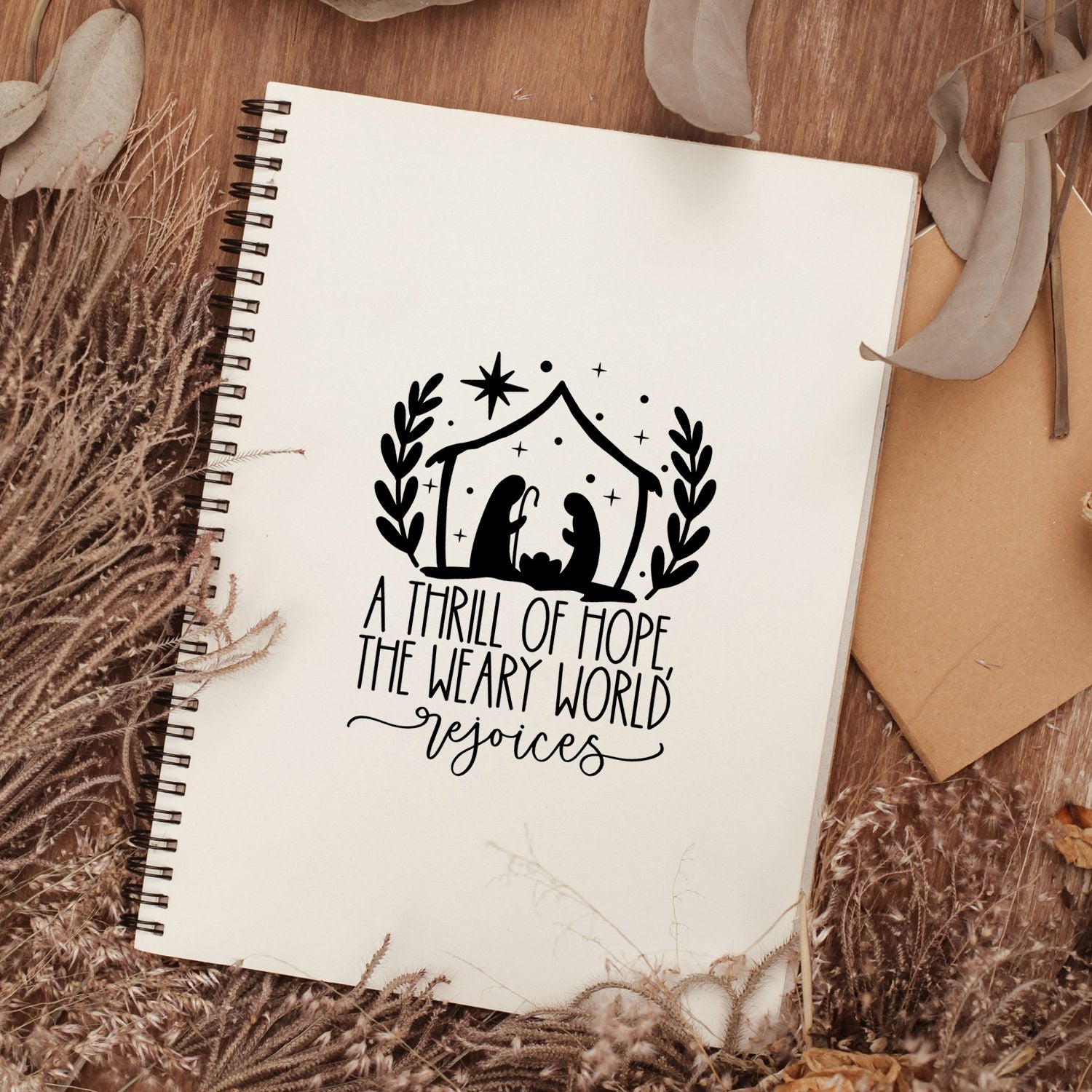 Nativity Christmas rubber stamp with A thrill of hope, the weary world rejoices on a notebook, perfect for faith journaling.