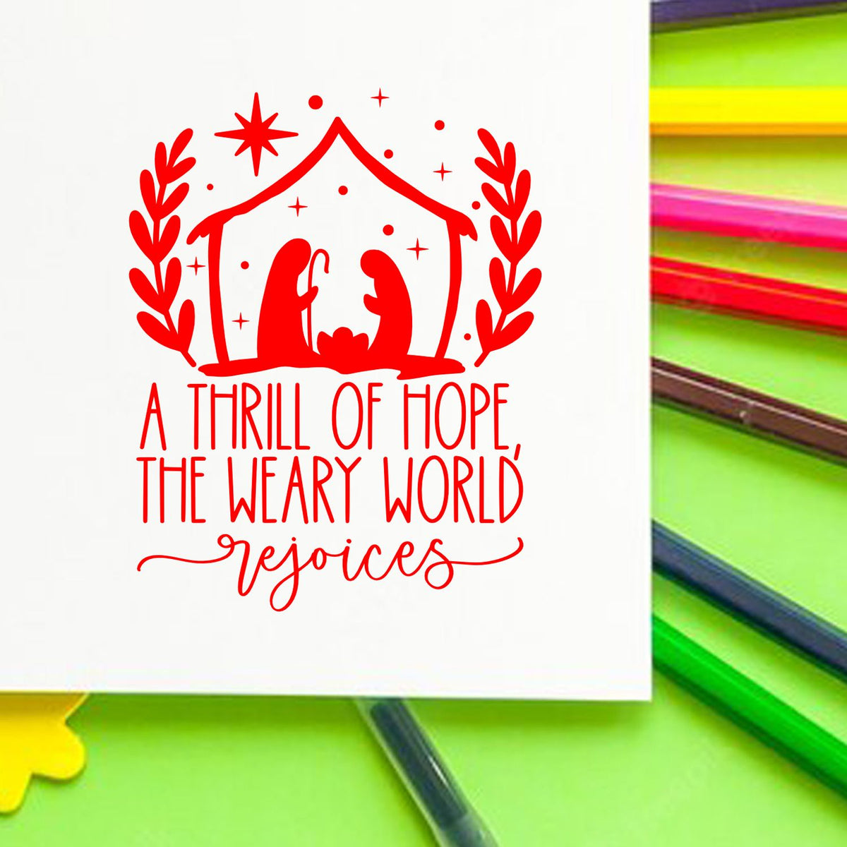 Christmas rubber stamp design featuring a nativity scene and the quote, A thrill of hope, the weary world rejoices.