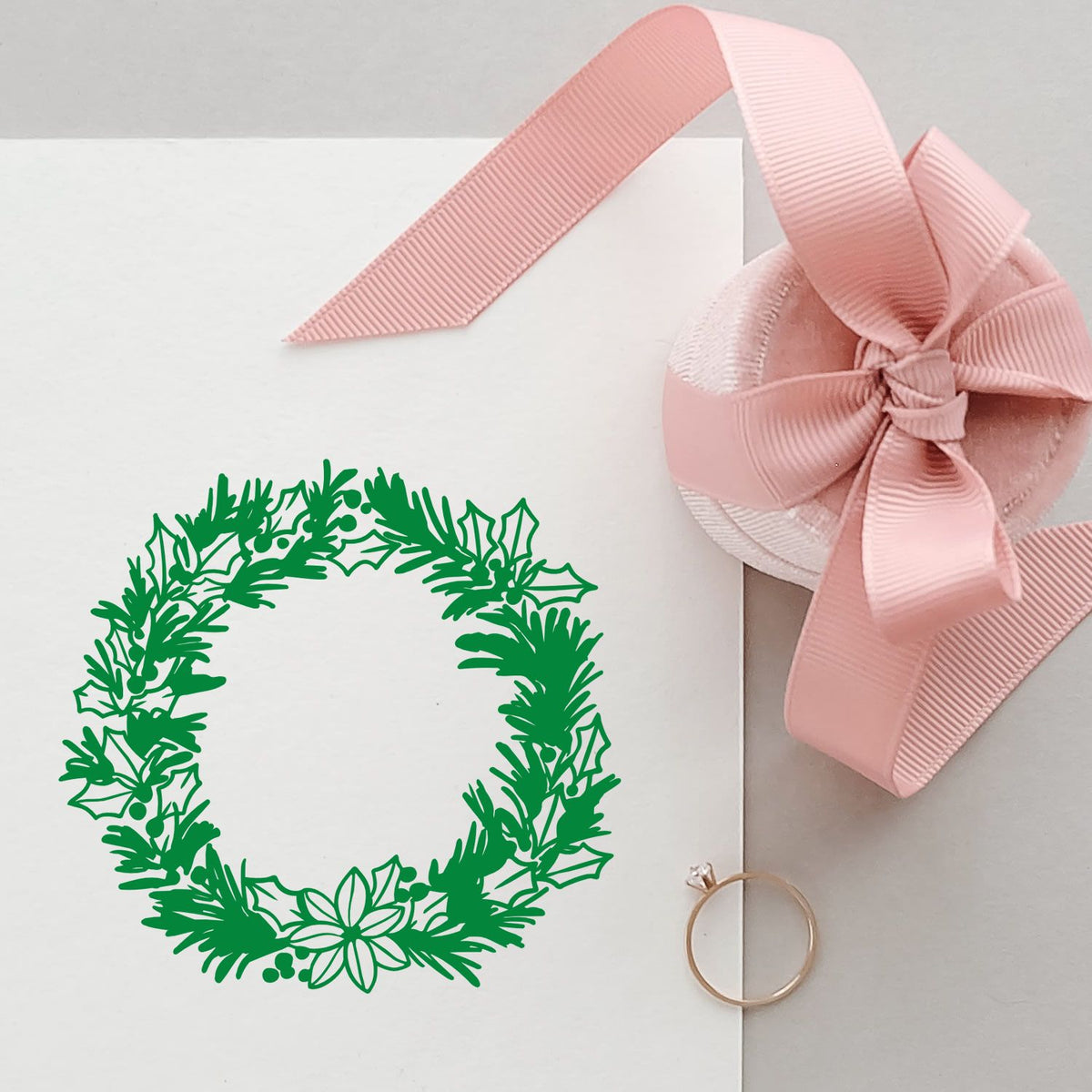Christmas holly wreath rubber stamp for greeting cards, gift tags and festive packaging with pink ribbon accents.