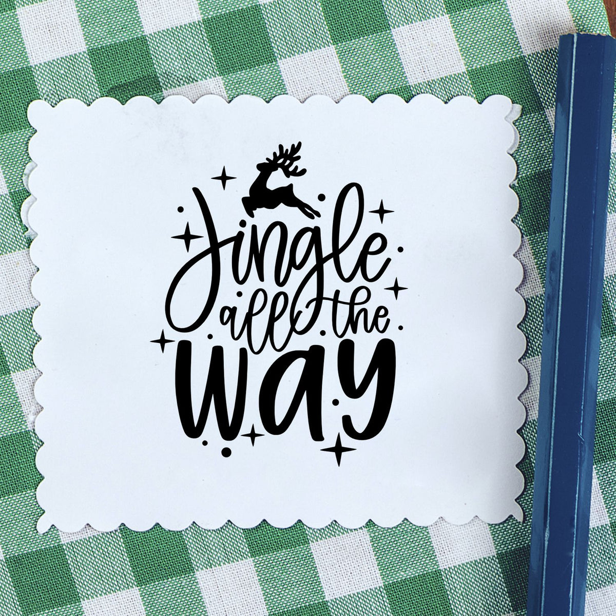 Christmas rubber stamp with Jingle All the Way lettering, reindeer silhouette, and stars on scalloped paper.